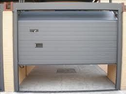 Una puerta de garaje con la puerta abierta y una pared de ladrillos detrás de ella.