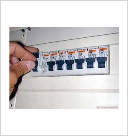 Una persona sostiene un disyuntor en su mano.