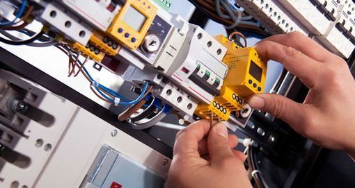 Una persona está trabajando en un panel eléctrico.