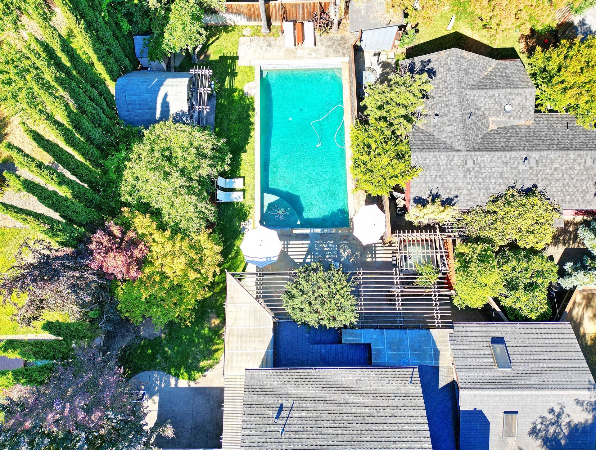 An aerial view of a house with a large swimming pool