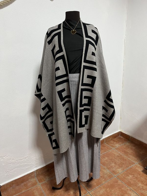 Dos faldas plisadas con cinturones colgadas en un perchero. Una es marrón y la otra granate.