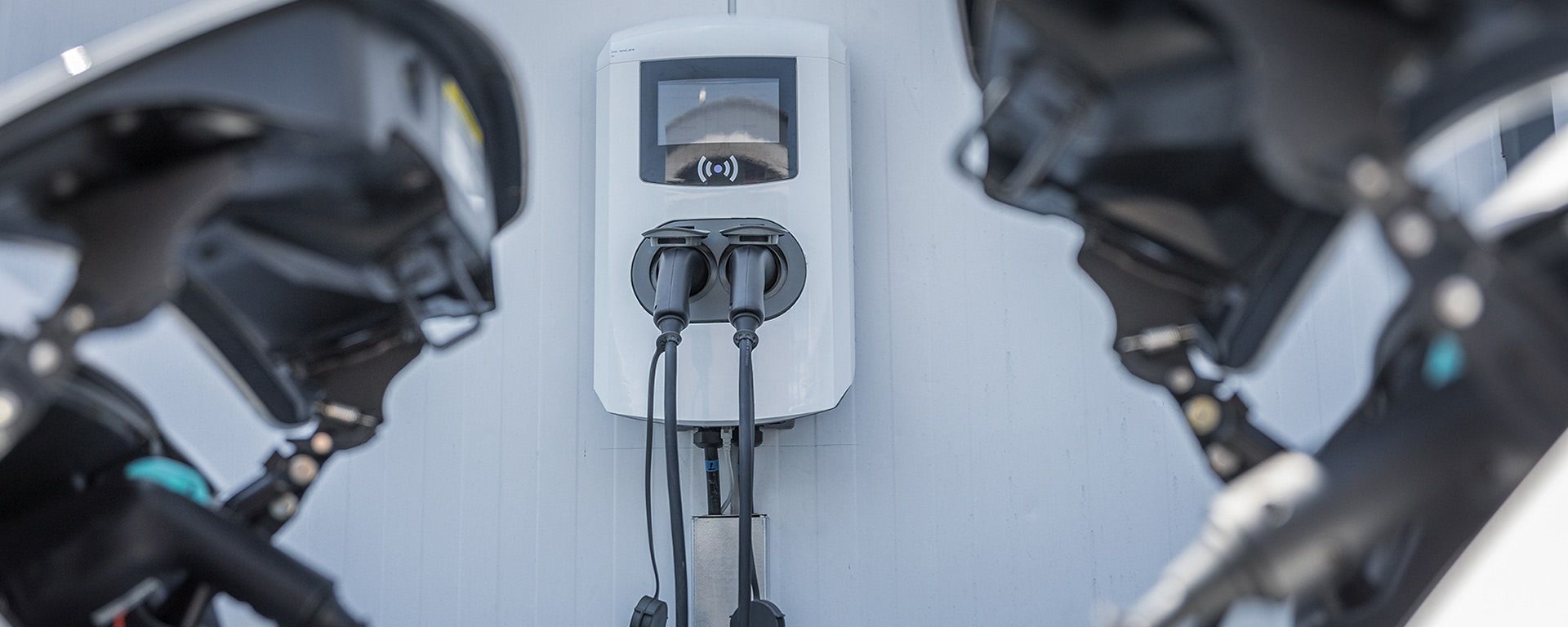 Eine Nahaufnahme eines Motorrads, das an einer Ladestation aufgeladen wird.