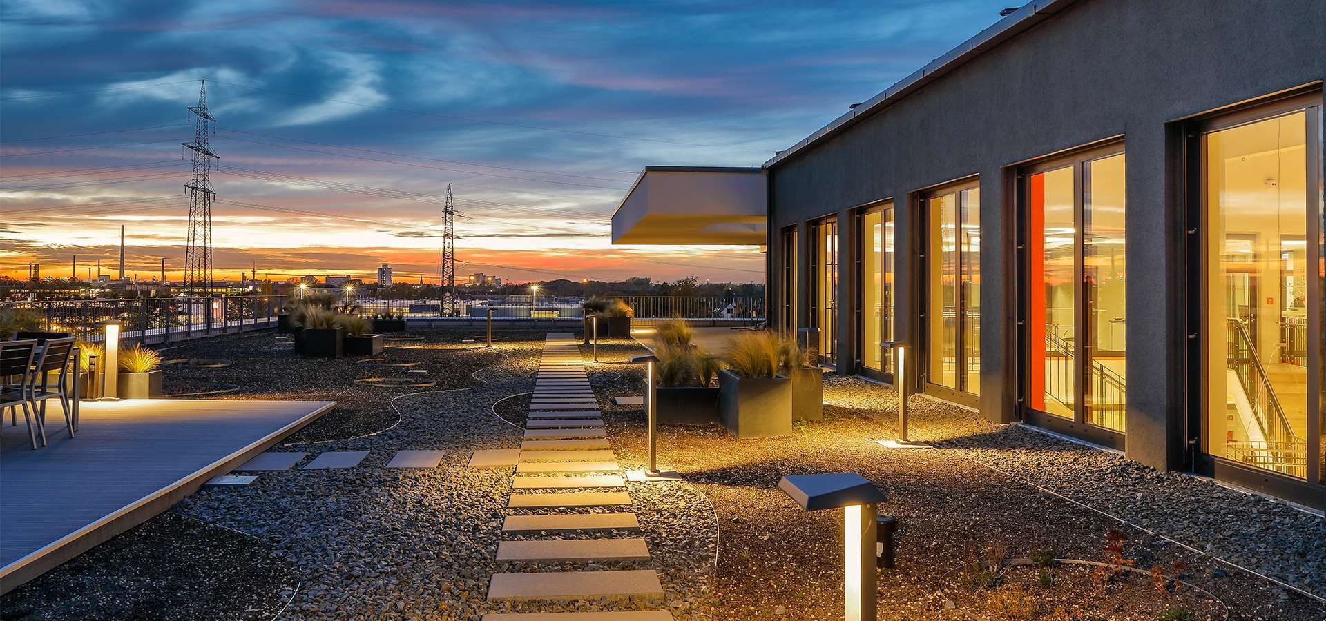 Eine Dachterrasse mit Blick auf die Stadt bei Sonnenuntergang.