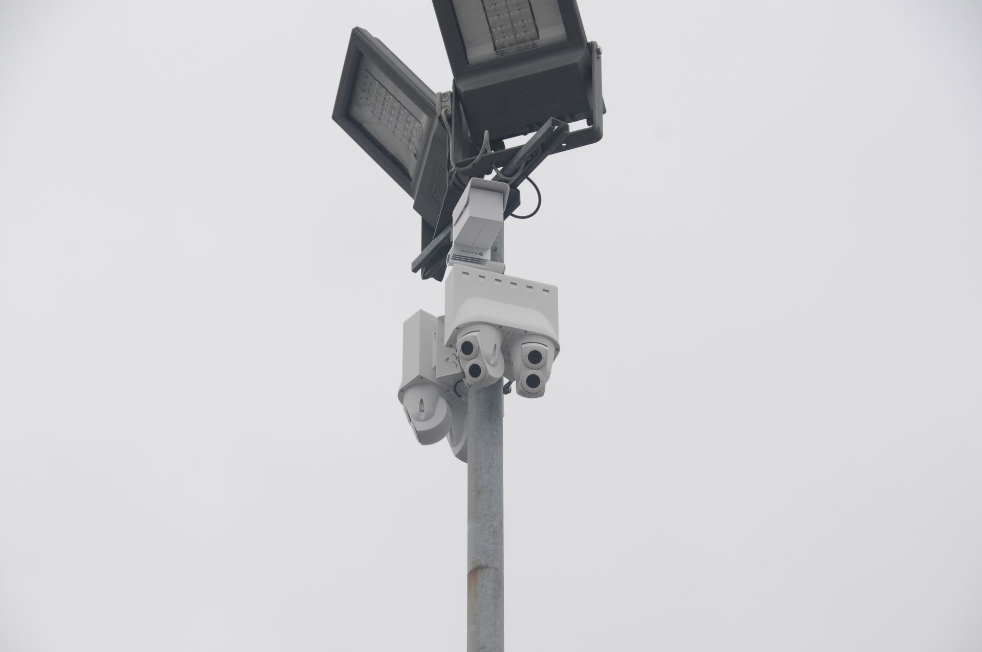 Eine Person installiert eine Überwachungskamera an einer Wand.