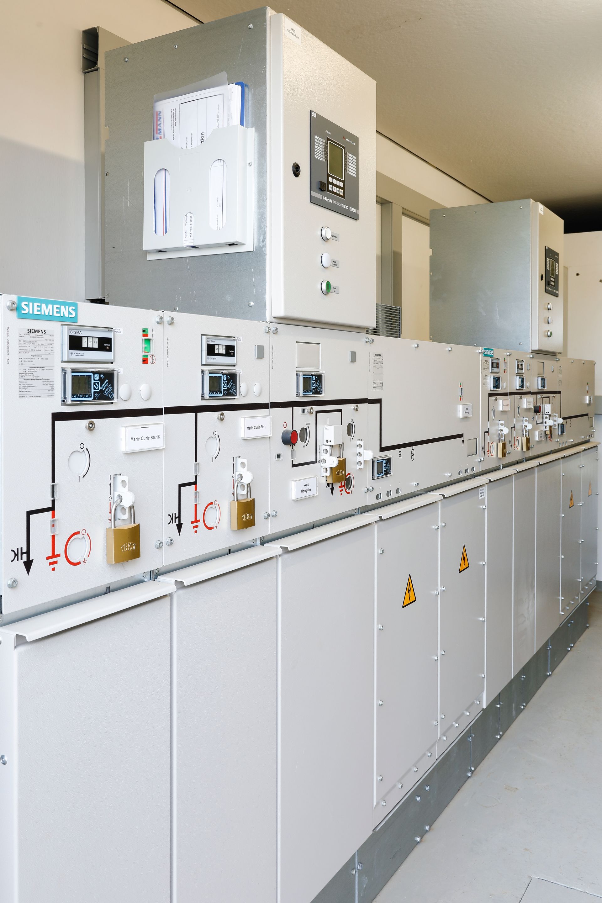 Eine Reihe weißer Schränke voller Elektrogeräte in einem Raum.