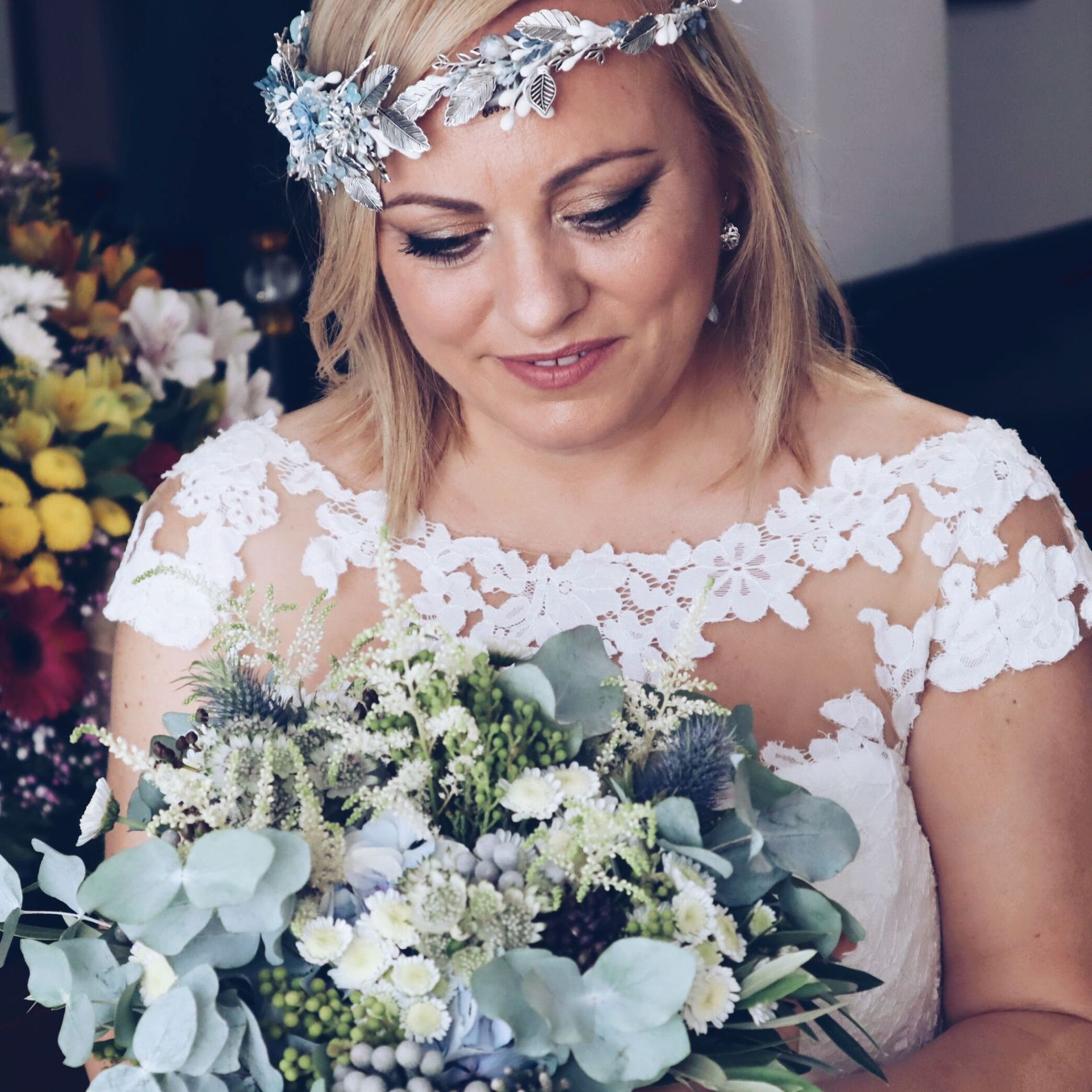 Una mujer con un vestido de novia sostiene un ramo de flores.