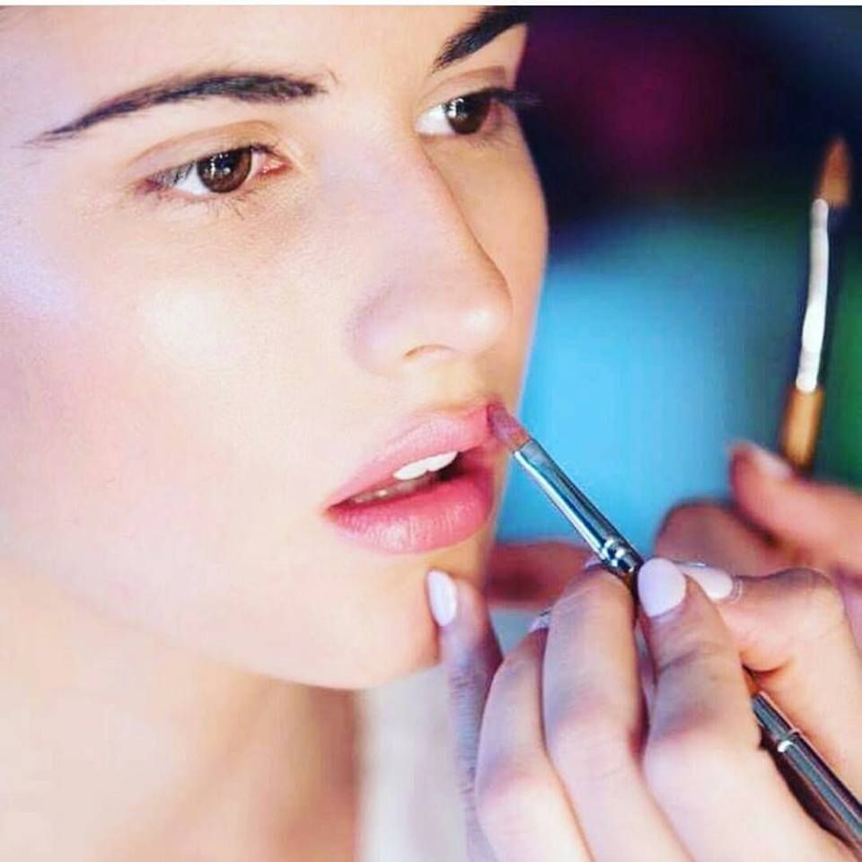 Una mujer se aplica maquillaje en la cara con un bolígrafo.