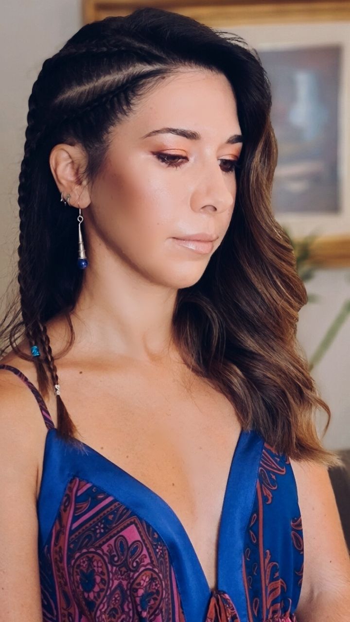 La mujer lleva un vestido azul y pendientes.
