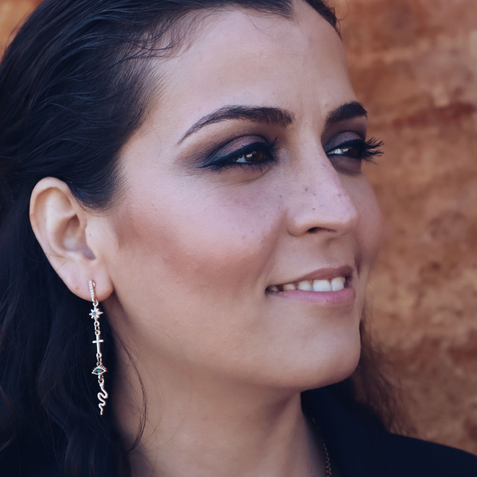 Un primer plano de una mujer que lleva un par de pendientes.