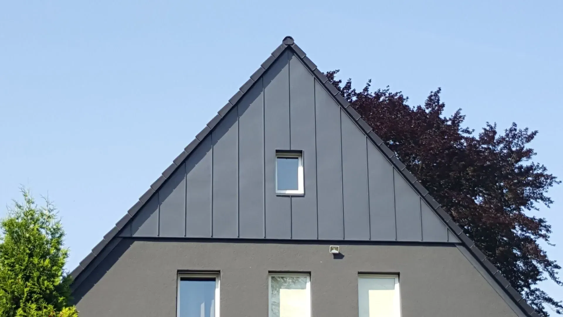 Ein Haus mit einem dreieckigen Dach und einem Fenster