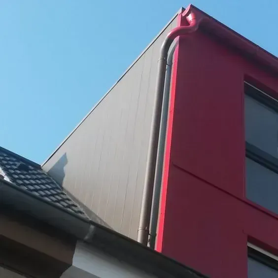Ausgebauter Dach mit Fenster und roter Fassade.