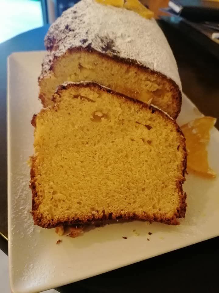 Un pastel con azúcar glas encima está en un plato blanco.