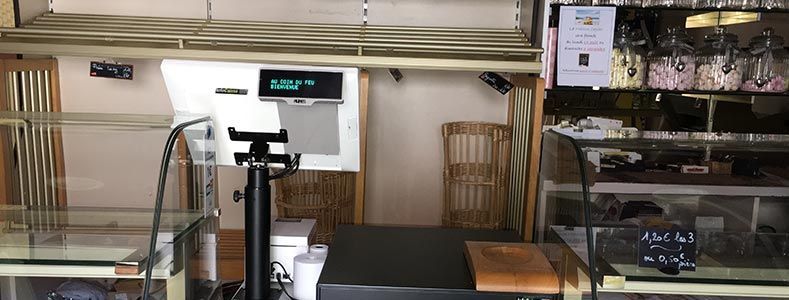 Un comptoir de boulangerie vide avec une balance numérique, des vitrines et des étagères pour les produits.