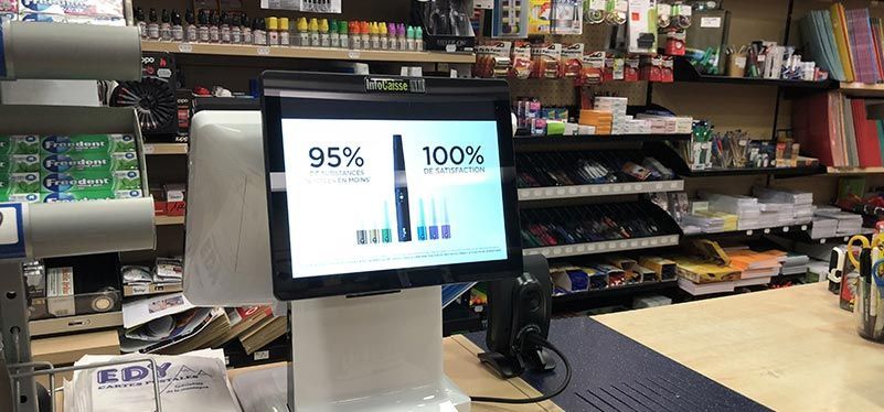Un présentoir sur le comptoir d'un magasin affiche une publicité pour des produits de vapotage, comparant les pourcentages.
