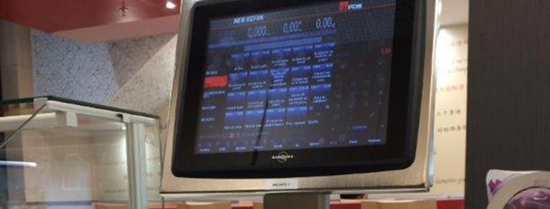 Un terminal de point de vente à écran tactile affiche une interface de menu numérique dans un commerce de détail ou un établissement de restauration.