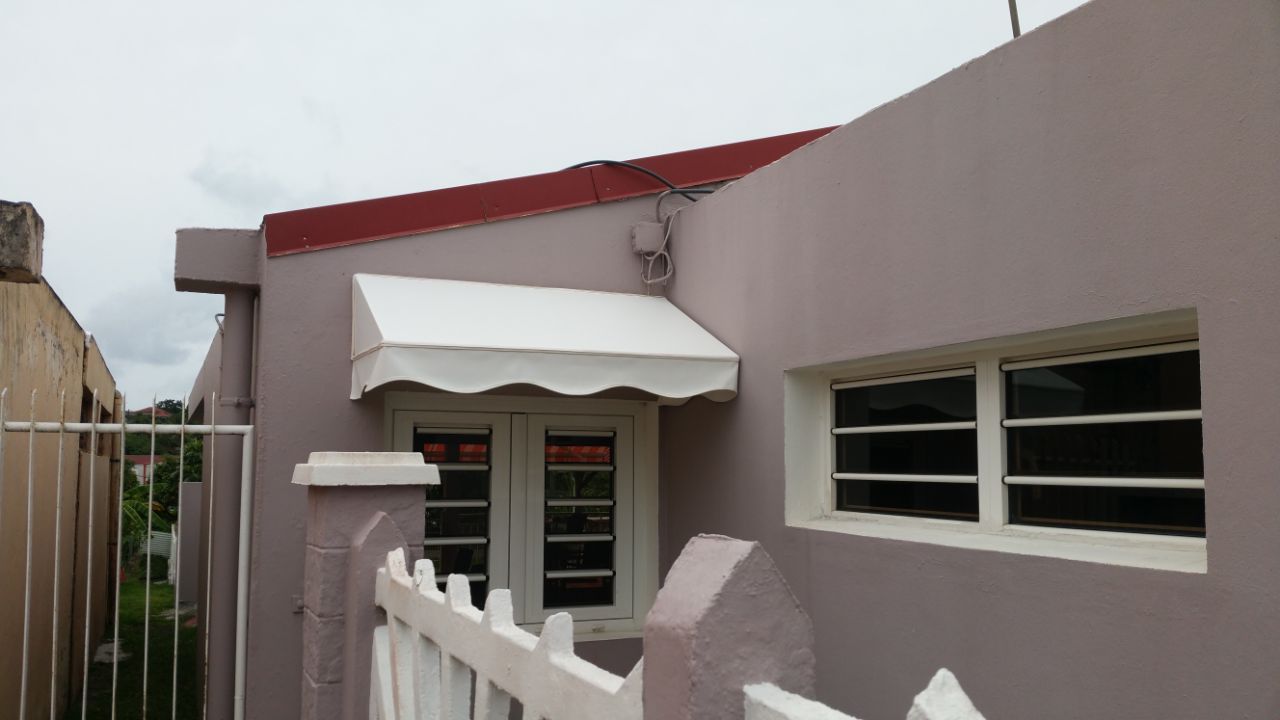 Store banne blanc installé au-dessus d'une porte d'entrée