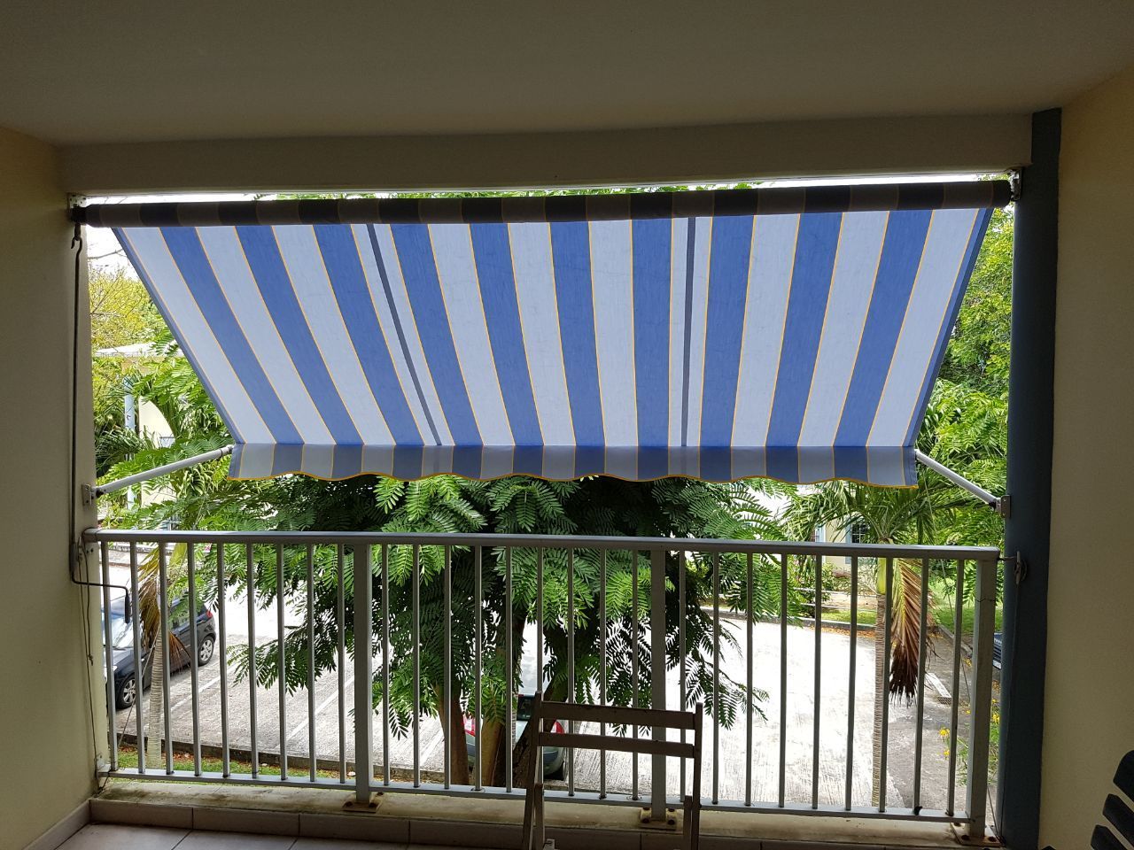 Store banne rayé bleu et blanc devant un balcon