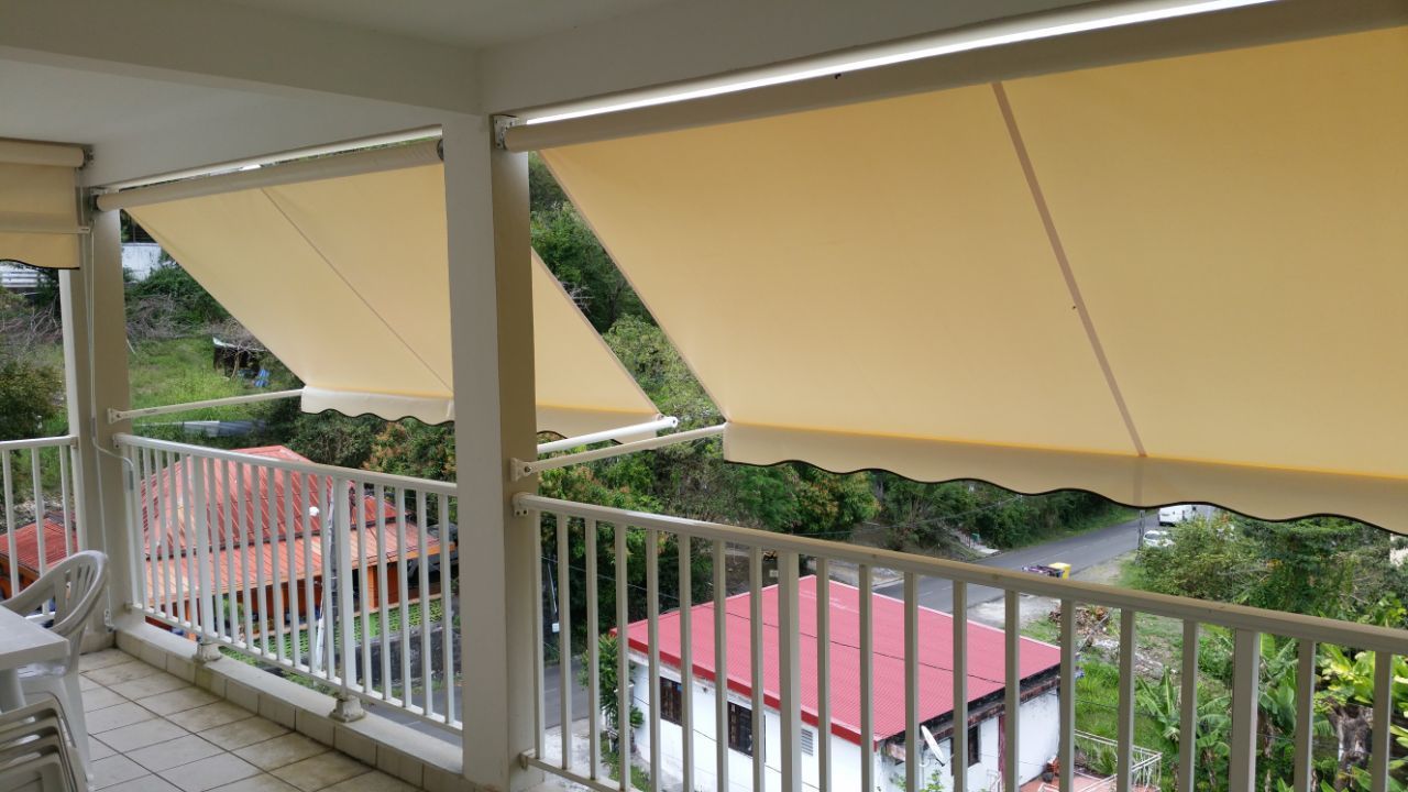 Store banne jaune citron pour un balcon