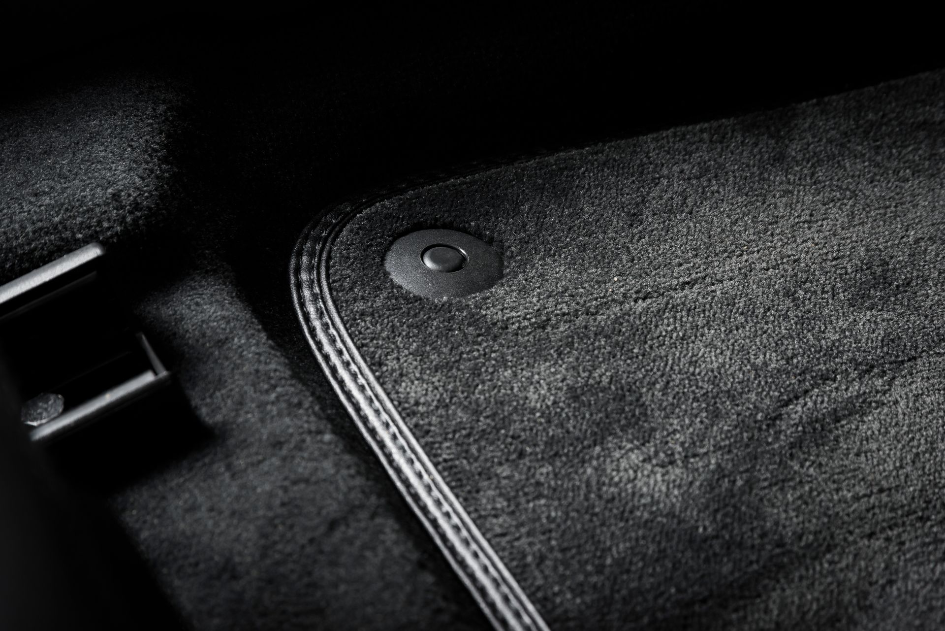 Tapis de sol de voiture noir avec attache circulaire.