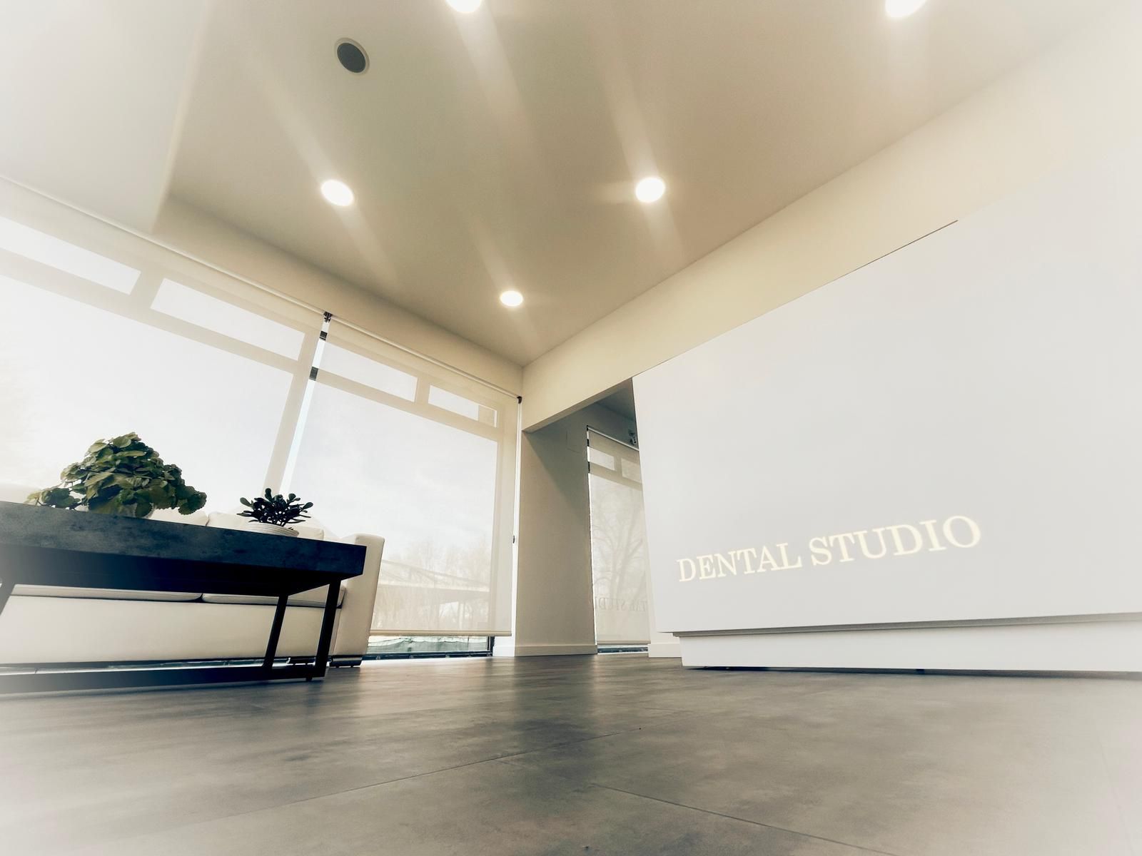 Interior luminoso y moderno de un estudio de yoga con esterillas, plantas y mostrador de recepción.