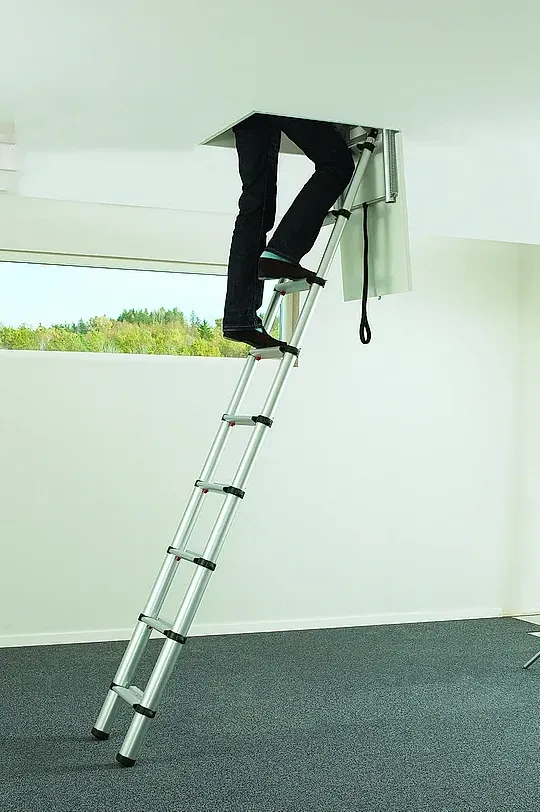 Una persona está usando una escalera para salir de un agujero en el techo.