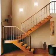 Una escalera de madera con barandilla de metal en una sala de estar.