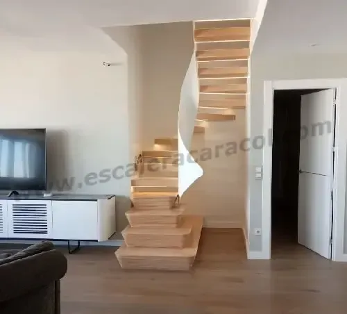 Una sala de estar con una escalera de madera y un televisor.