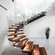 Una moderna escalera de madera con barandilla de vidrio en una casa.