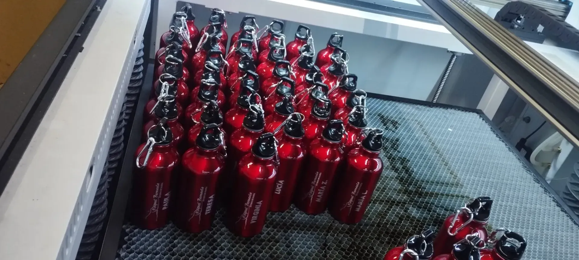 Un técnico con casco azul y chaleco reflectante habla por teléfono mientras trabaja en un ordenador portátil en un parque eólico.