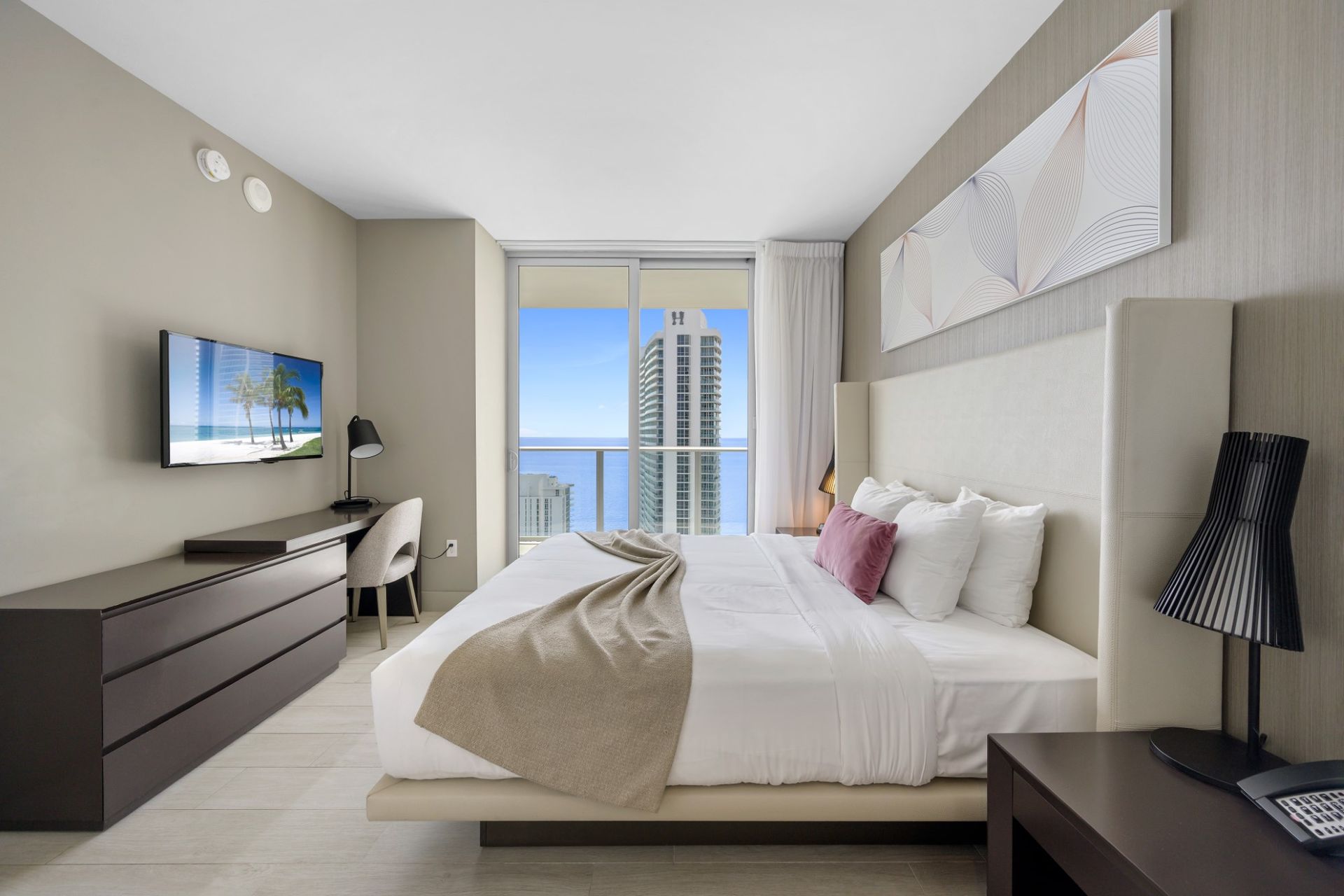 A bedroom with a large bed and a flat screen tv