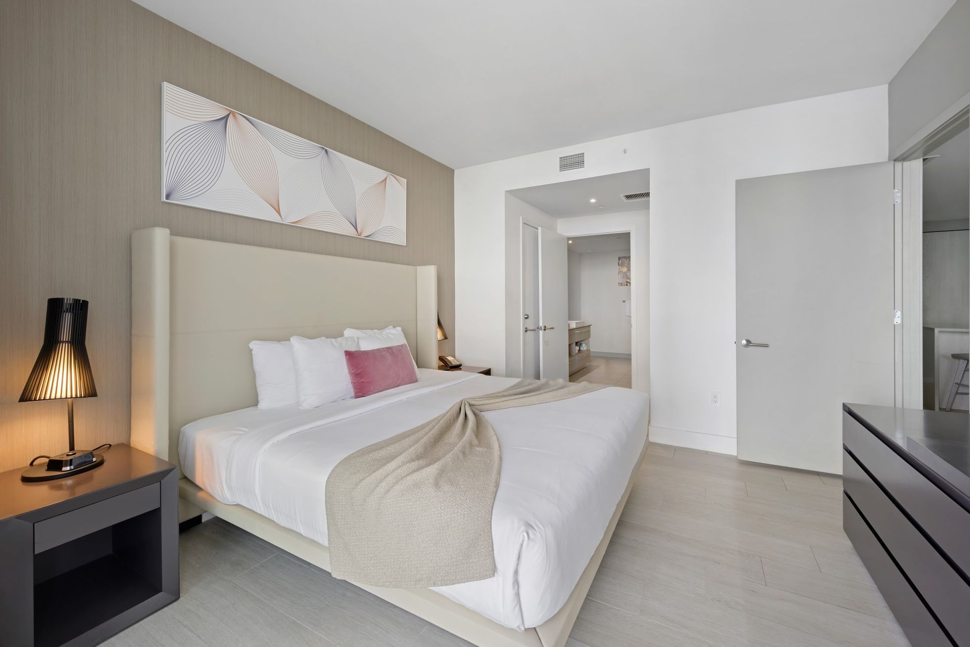 A hotel room with a king size bed and a nightstand.