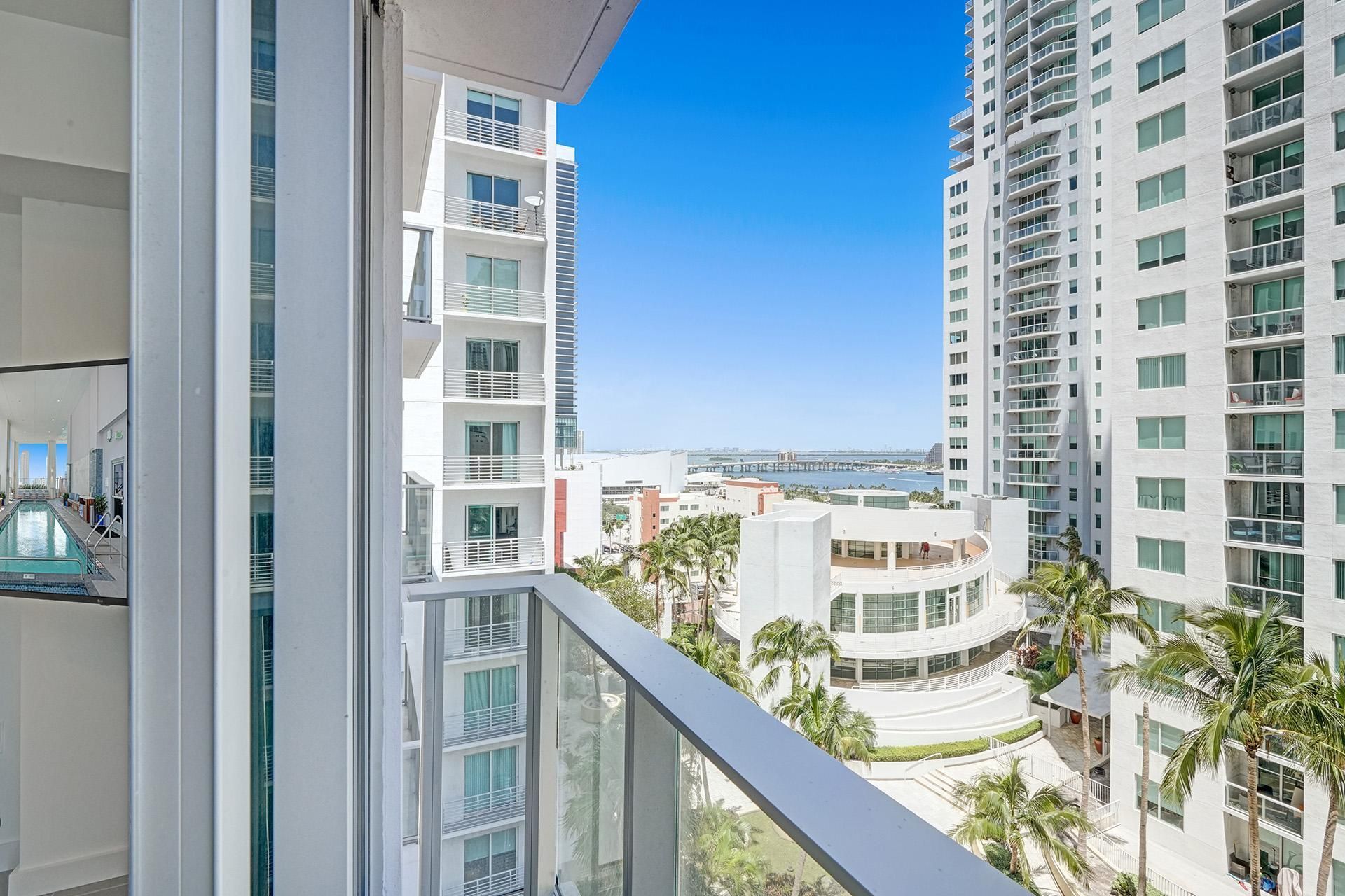 A balcony with a view of a city and palm trees(Studio for Stay Miami Getaways)