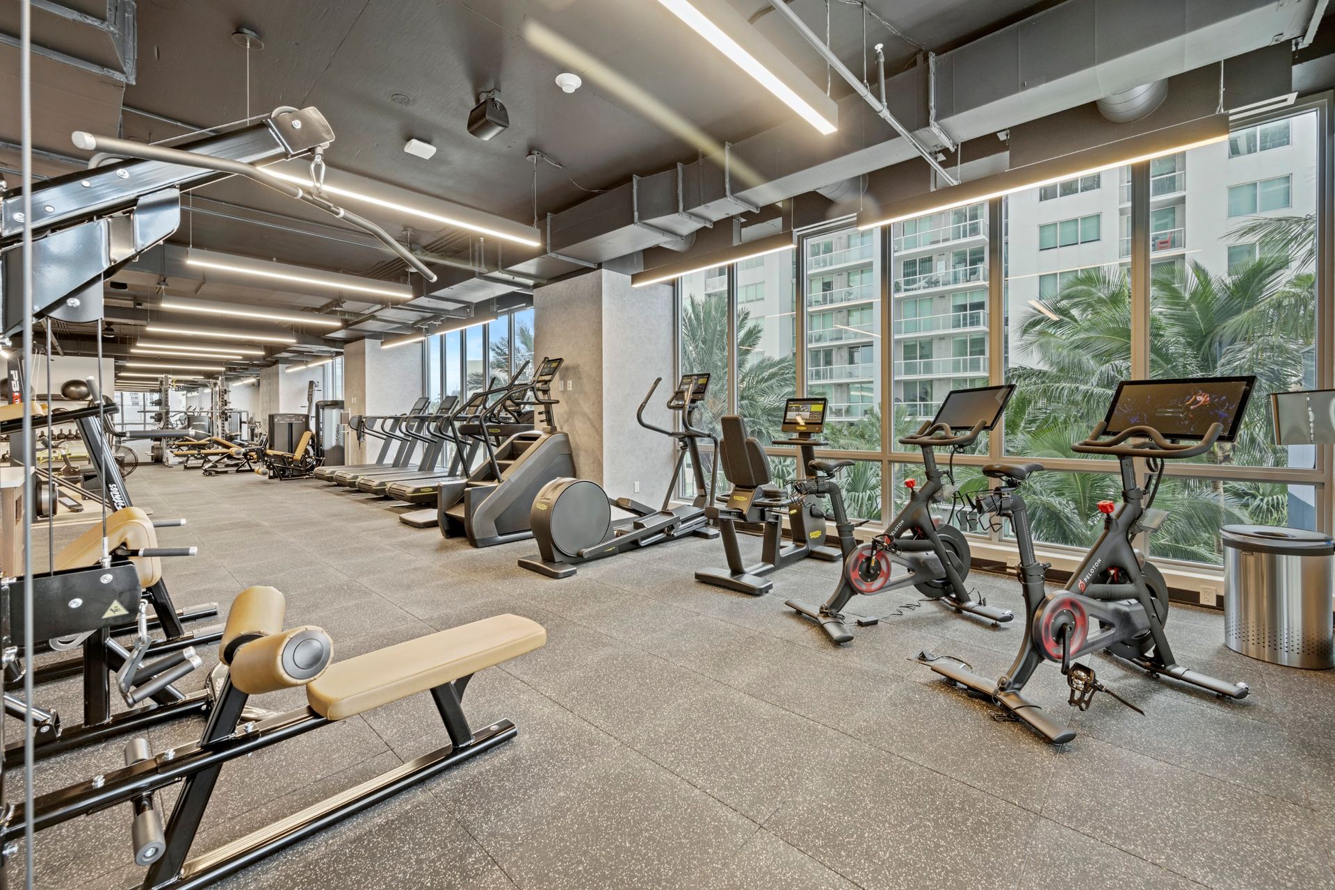 A large gym filled with lots of exercise equipment.