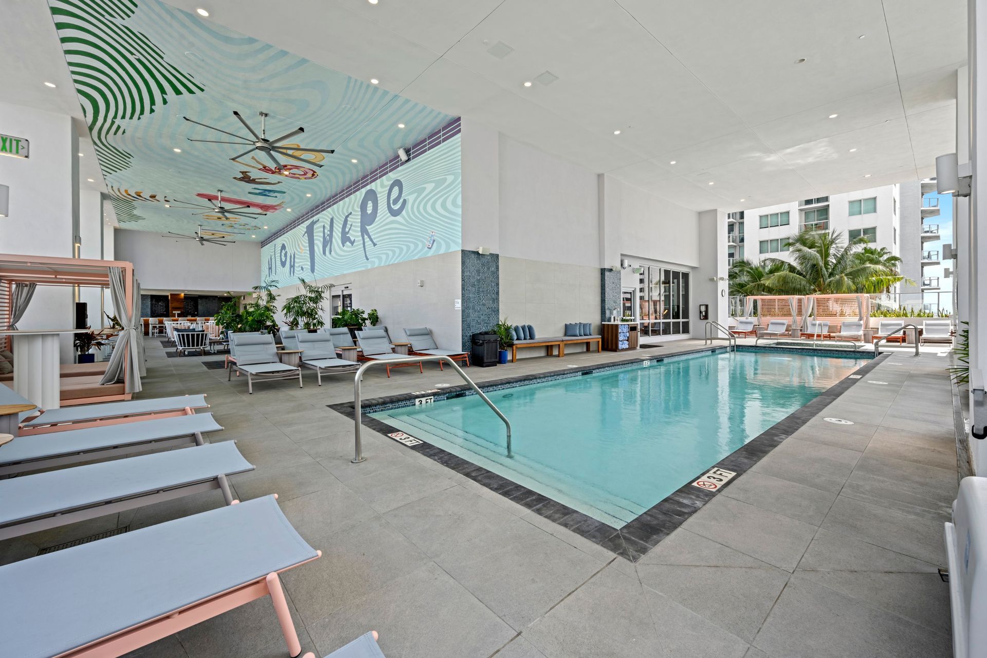 A large indoor swimming pool with a lot of chairs around it.