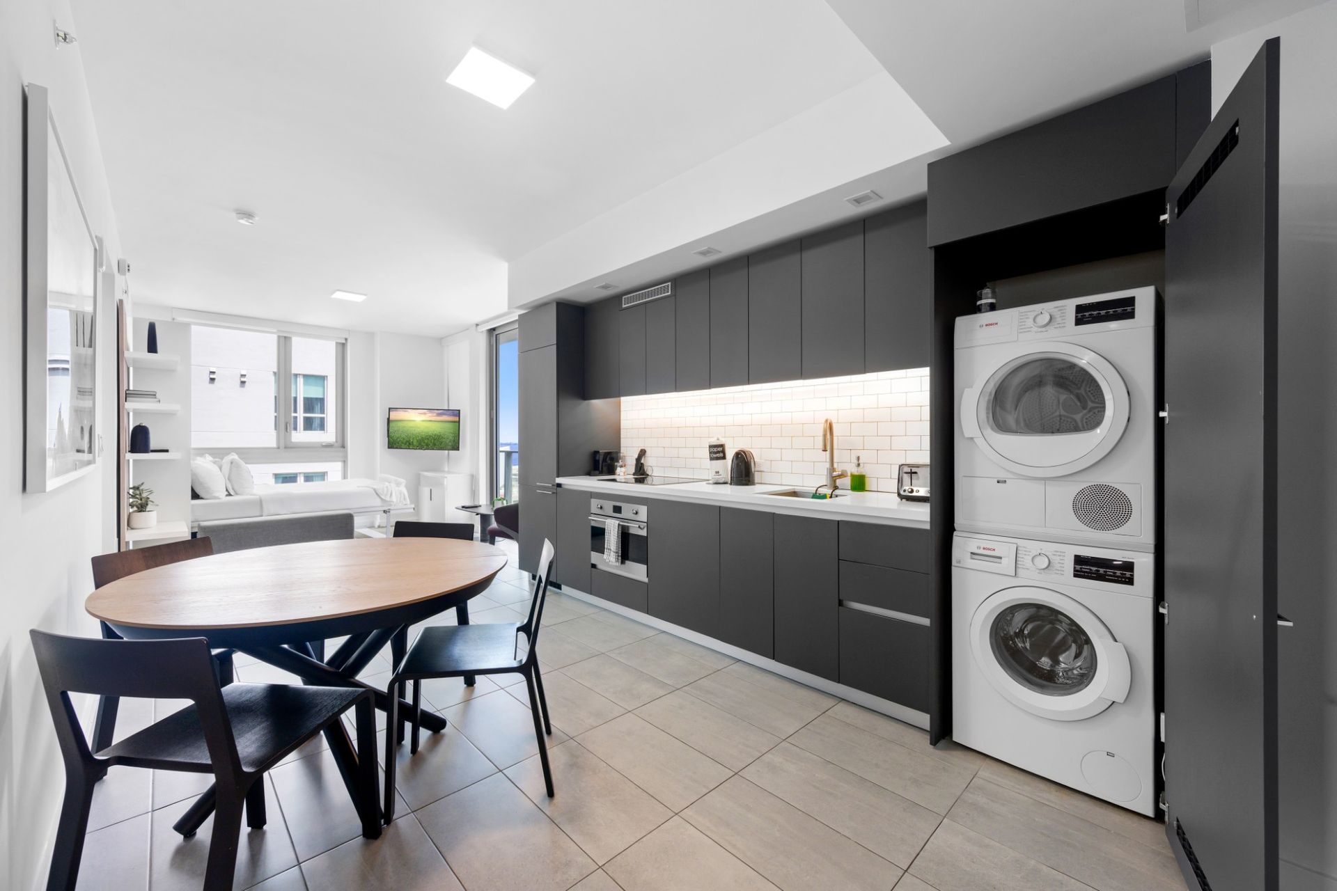 A kitchen with a washer and dryer stacked on top of each other.