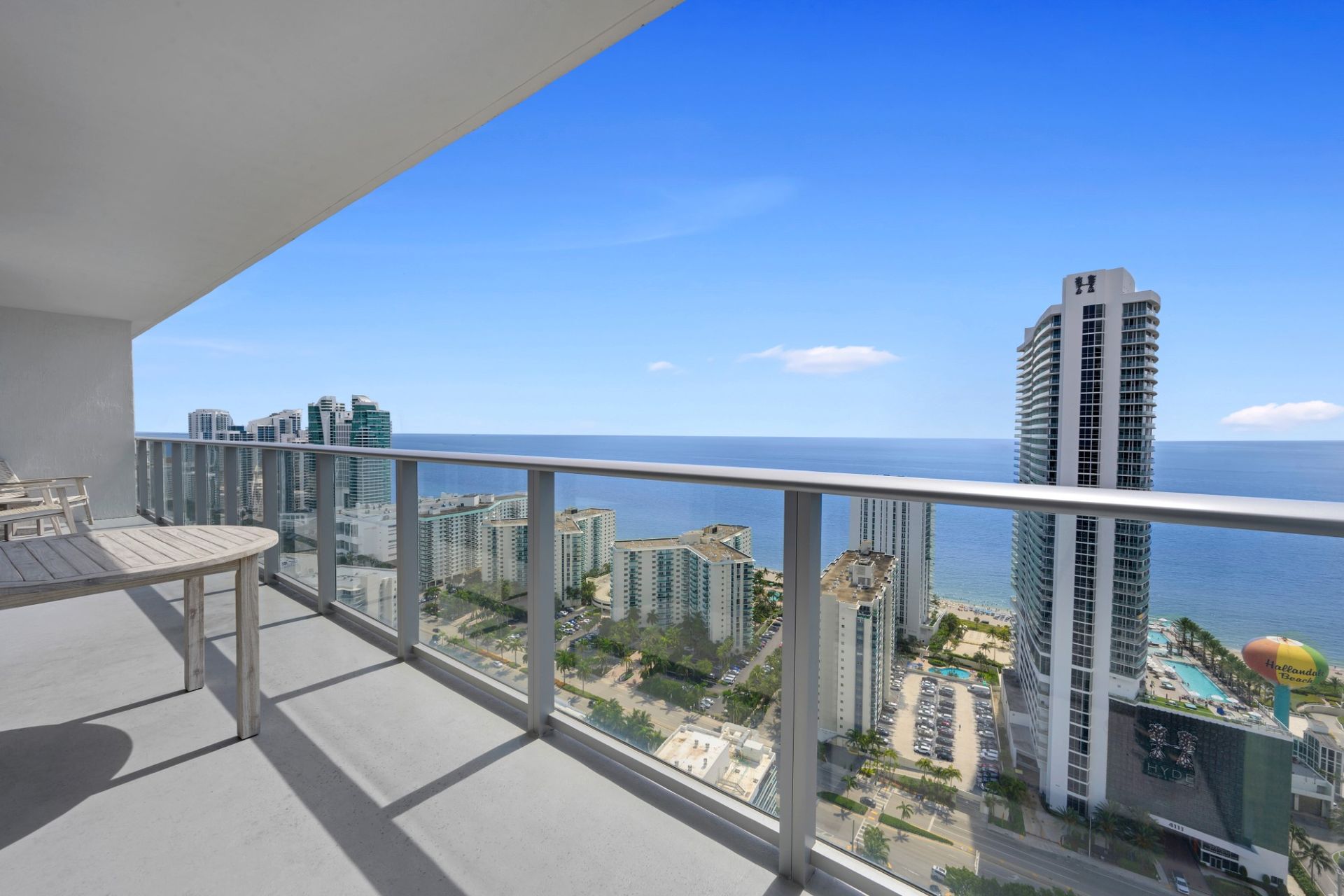 A balcony with a view of the ocean and buildings