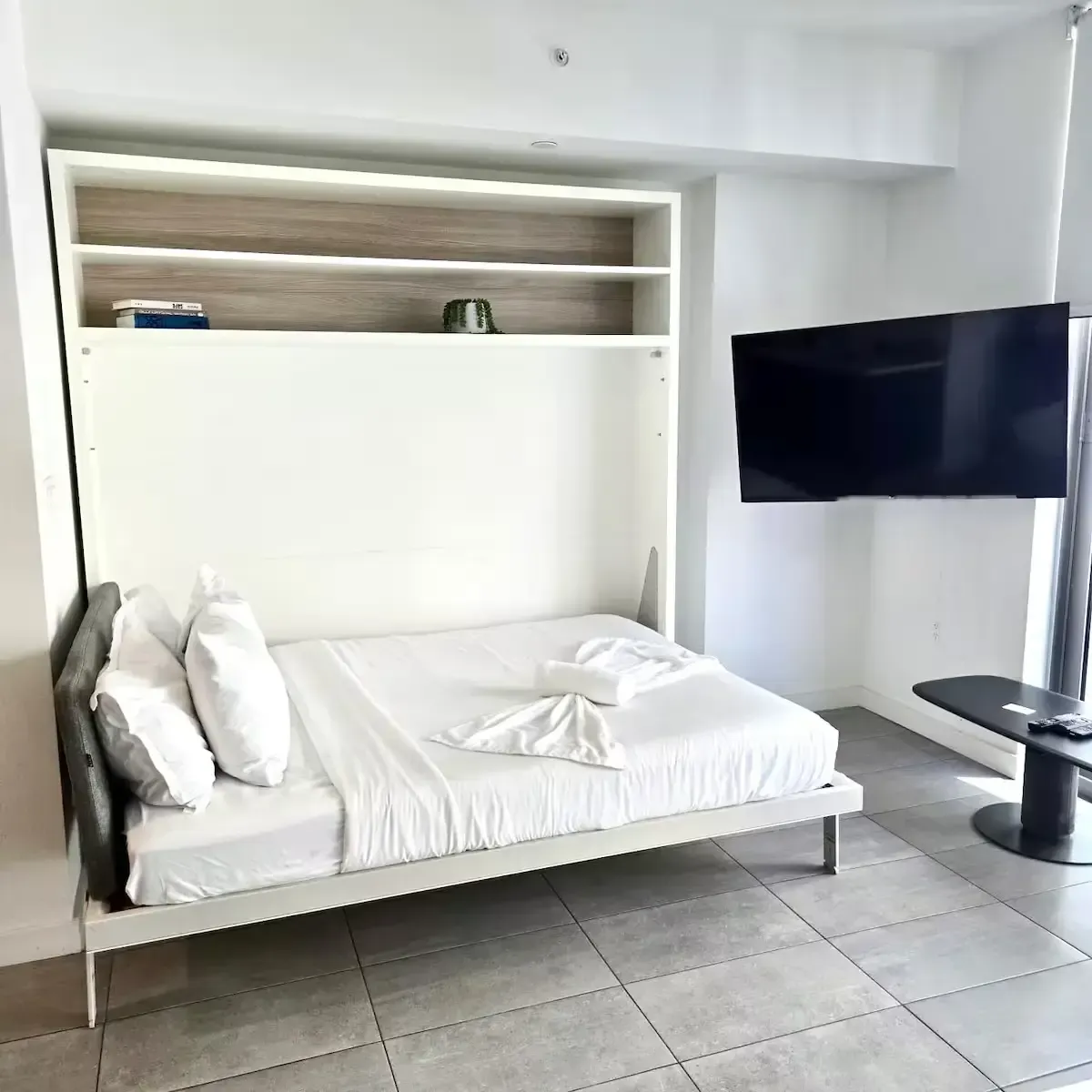 A bedroom with a bed and a flat screen tv.