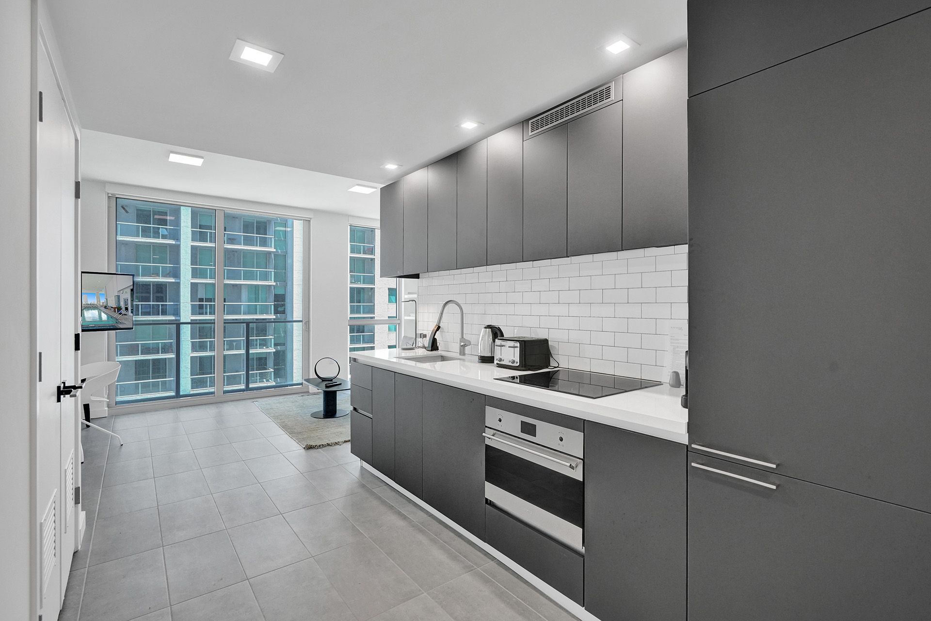 A bathroom with a toilet , sink , mirror and walk in shower. (Studio- Stay Miami Getaways)