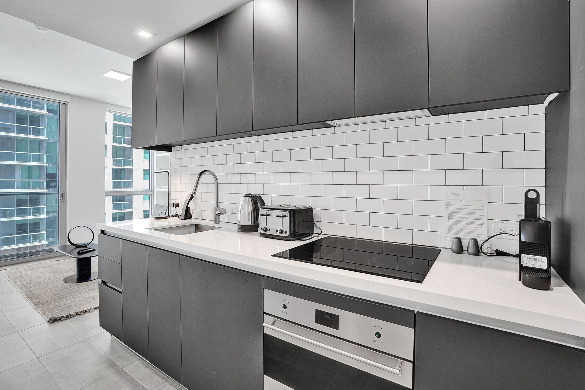 A black and white photo of a kitchen with stainless steel appliances.