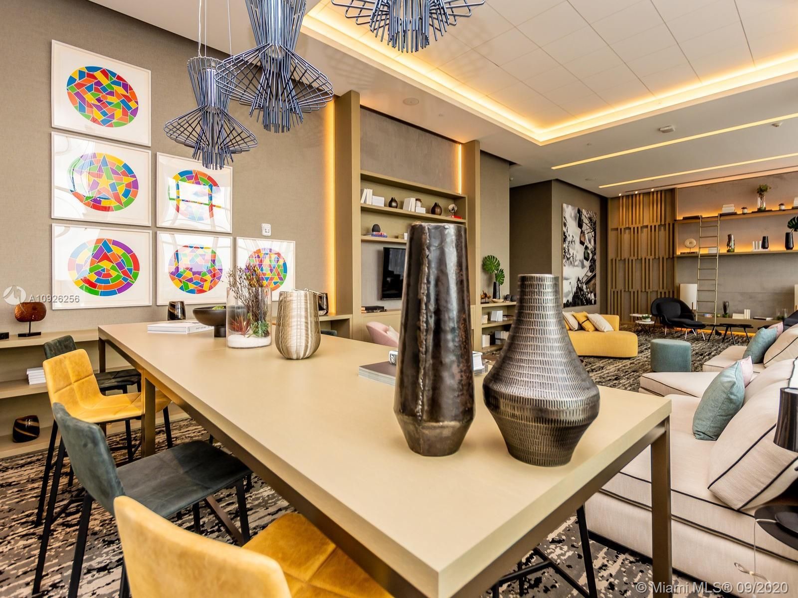 A dining room with a table and chairs and vases on it.