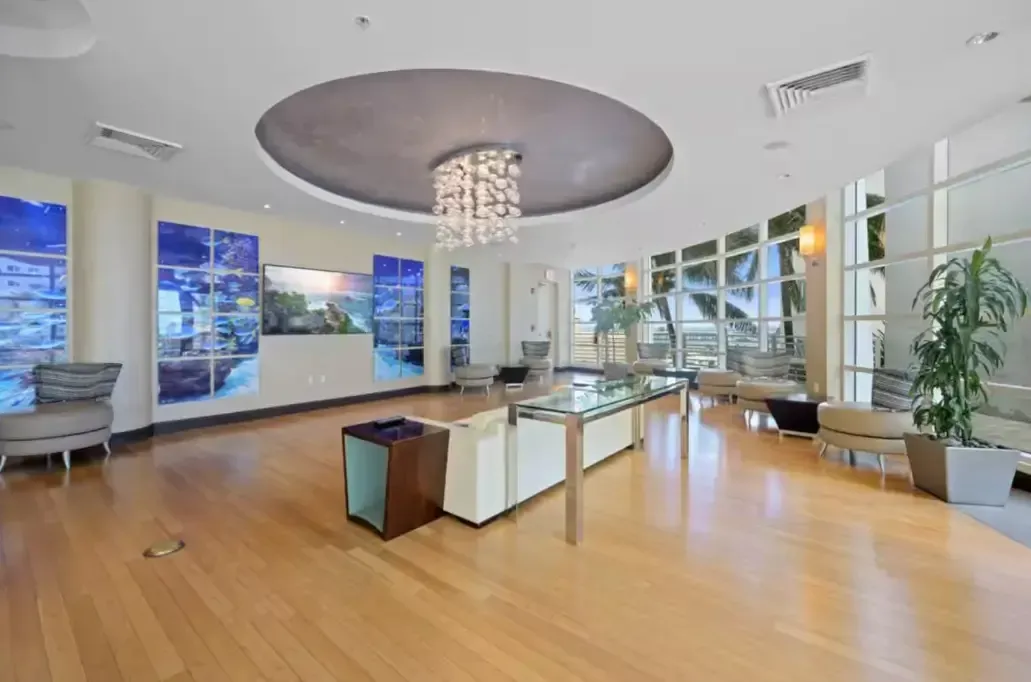 A large lobby with hardwood floors and a chandelier.