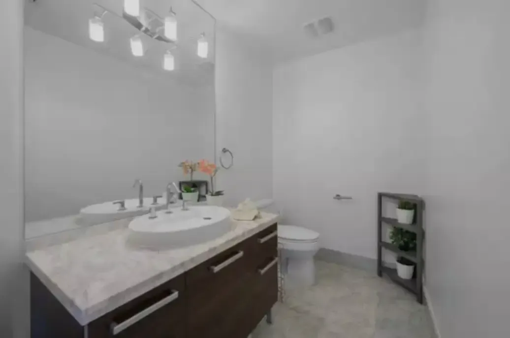 A bathroom with a sink , toilet and mirror.