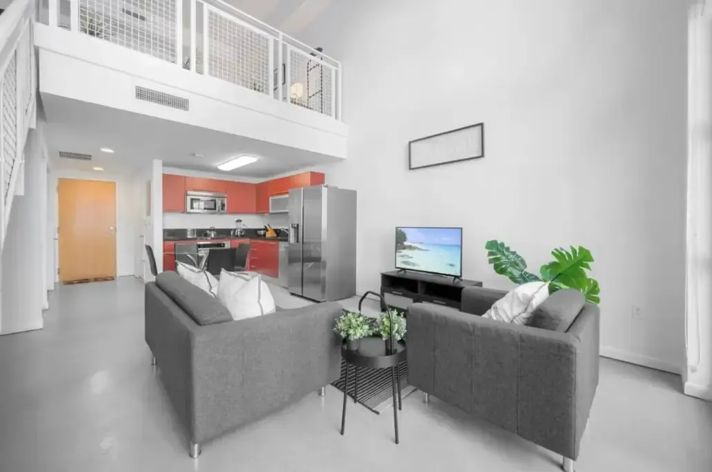 A living room with two couches and a flat screen tv.