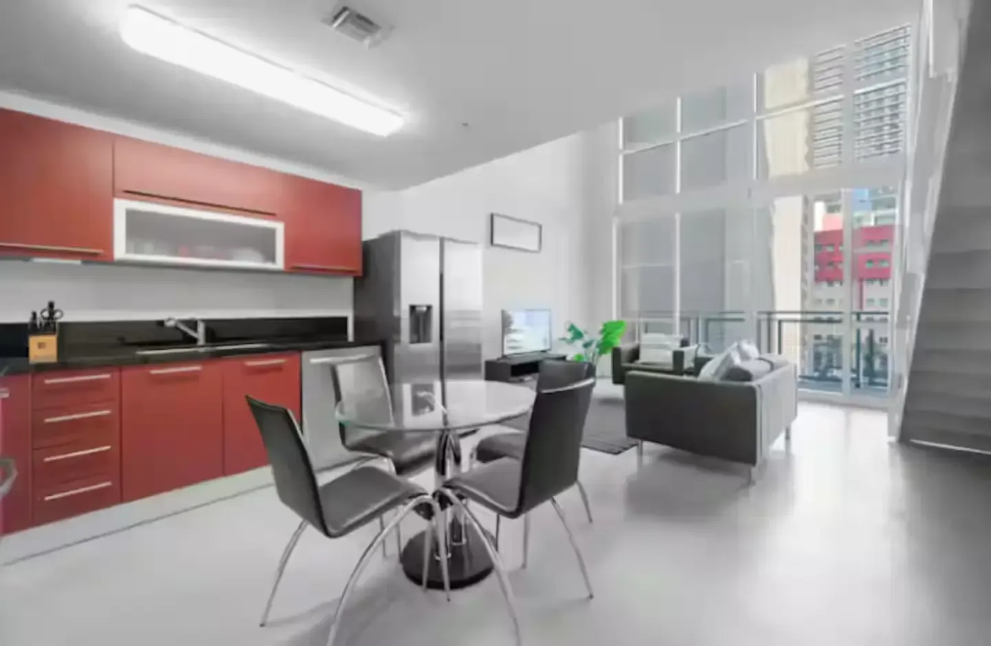 A kitchen with red cabinets and a dining table and chairs