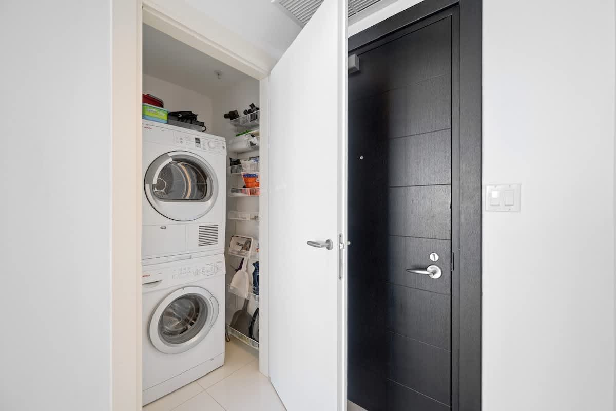 A laundry room with a washer and dryer stacked on top of each other.