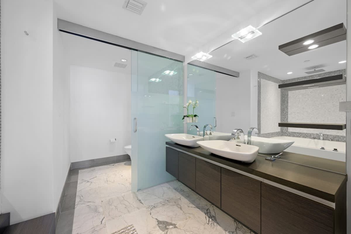 A bathroom with two sinks , a tub and a shower.