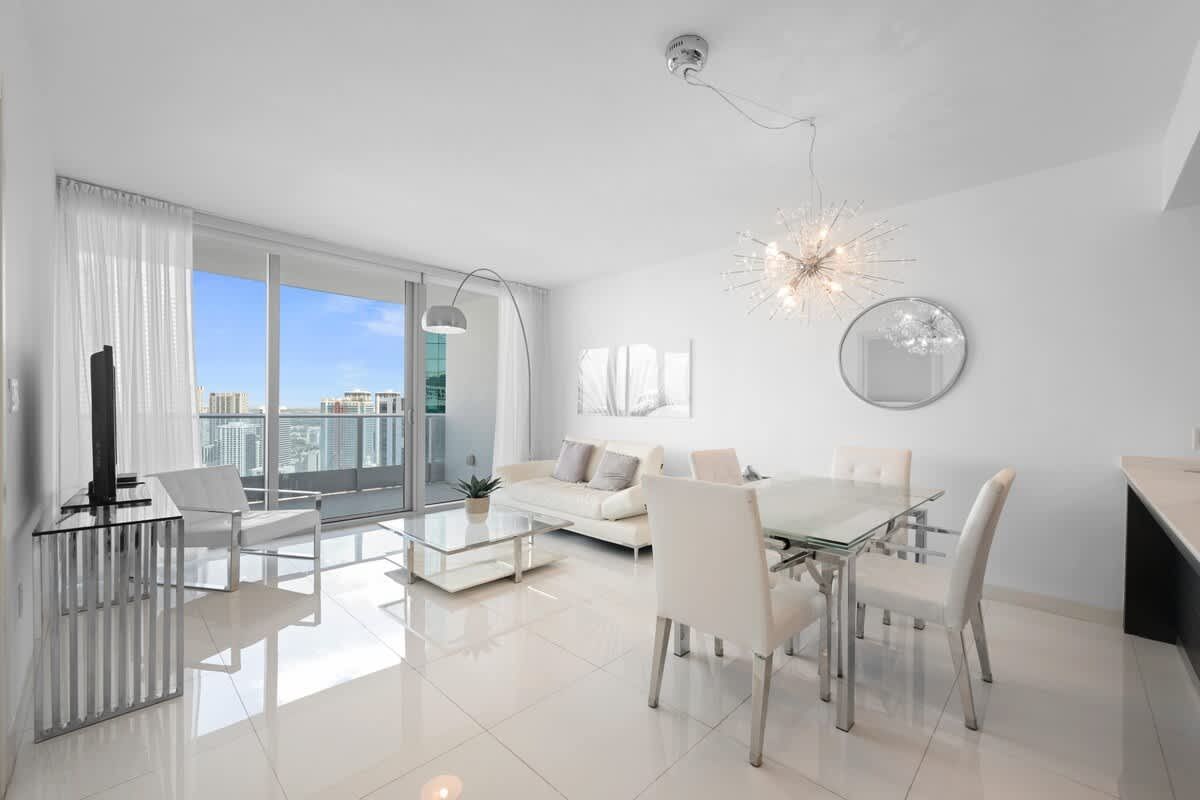 A living room with a dining table and chairs and a couch.