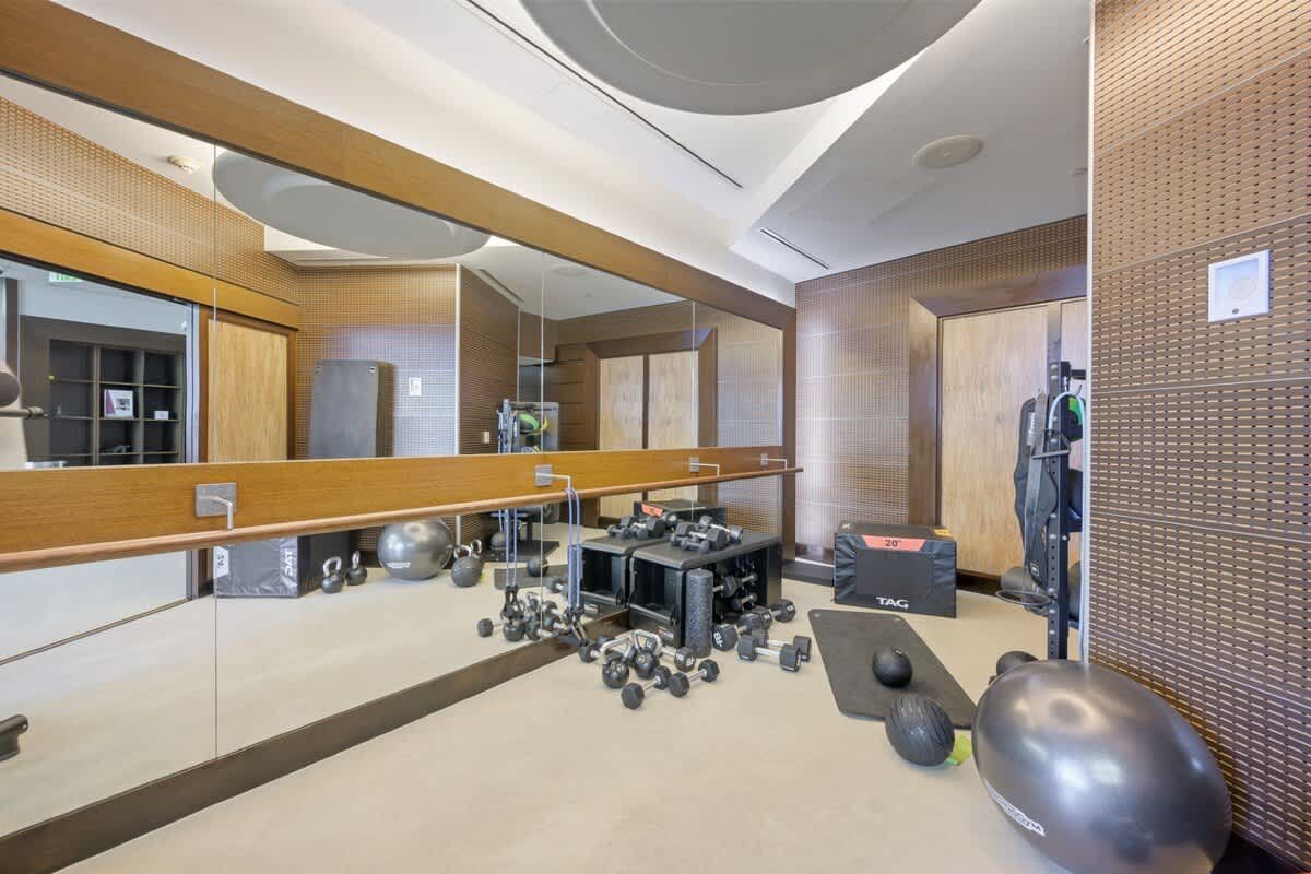 A gym with a lot of mirrors and exercise equipment.
