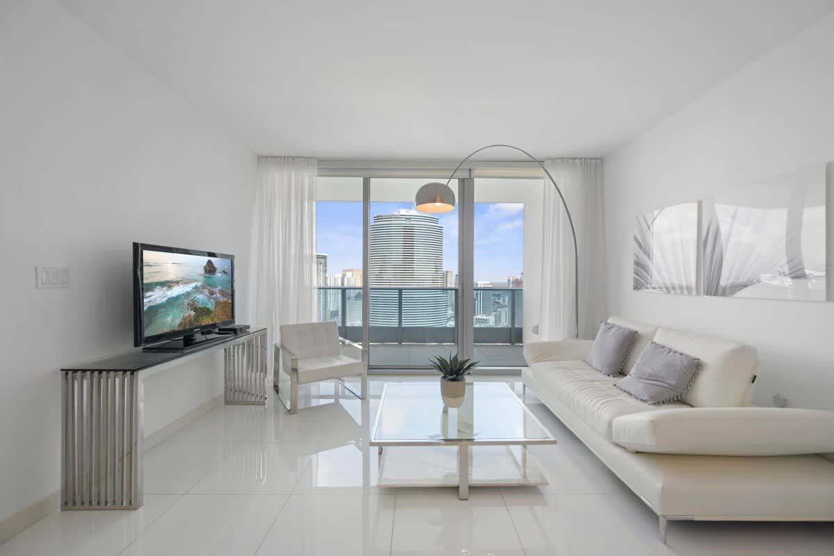 A living room with a couch , chair , table and television.