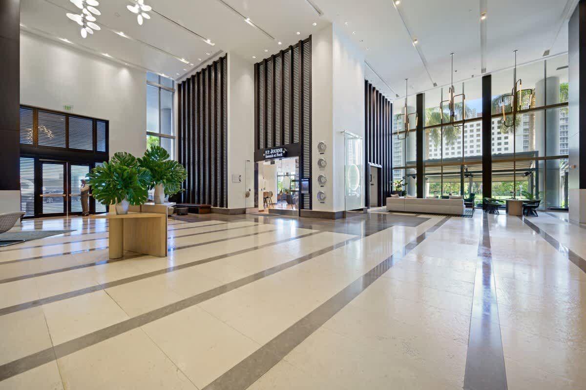 A large empty lobby of a building with a planter in the middle.
